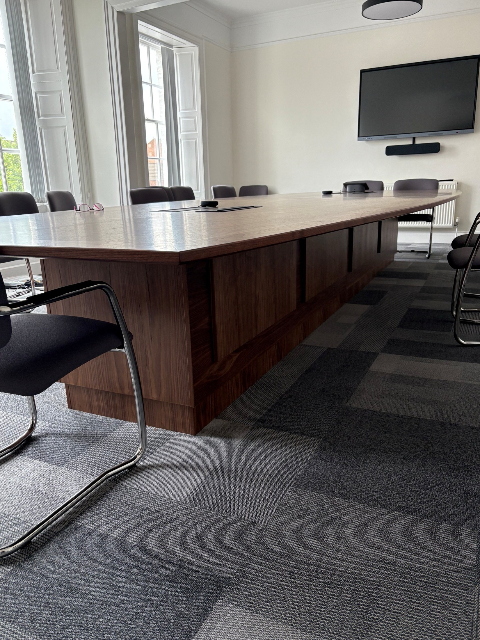 Close view of a large timber boardroom table with integrated power points