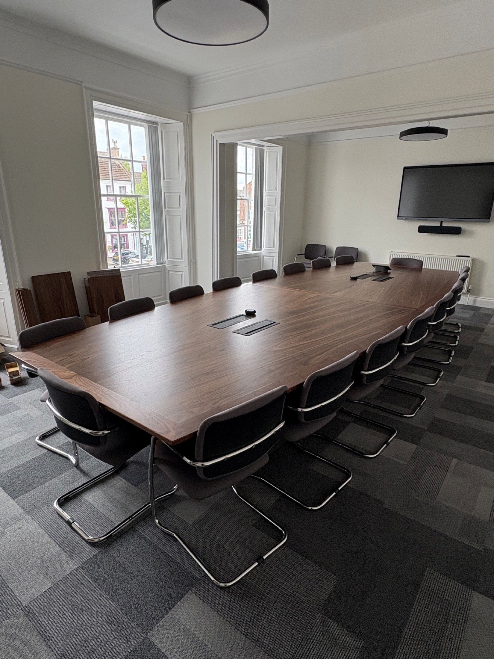 Boardroom with grey carpet tiles below a large meeting table